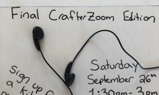 A handprinted poster reads "Queer Crafternoon: Final crafterzoom edition. Sign up for a kit at monoceros education dot ca slash kit dash sign up. Saturday September 26th 1:30 pm to 3 pm on Zoom. Earbuds are scattered on the poster. 